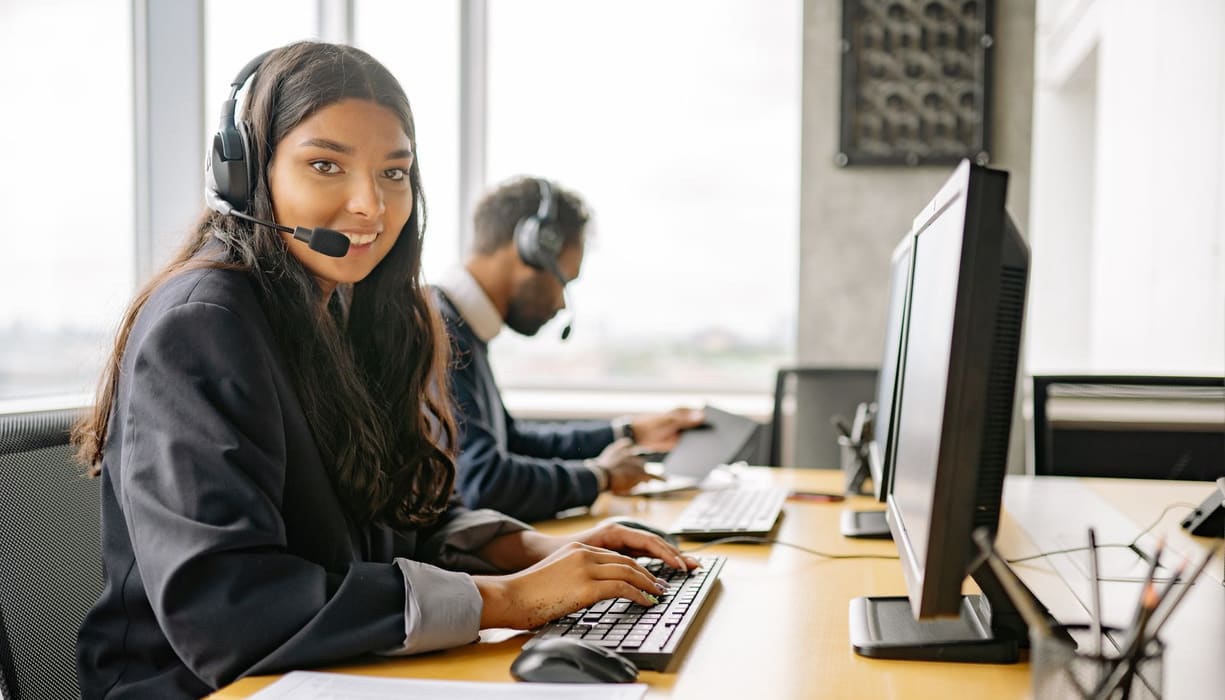 Support engineer with a headset at a helpdesk workstation